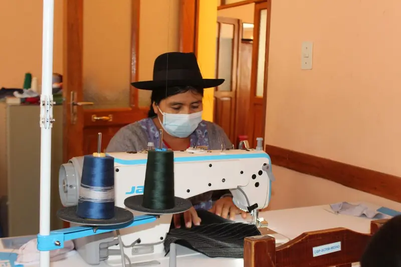 Mujer cosiendo en una máquina de coser industrial