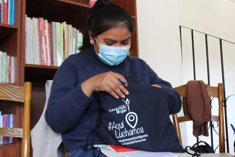 Mujer de la campaña #AquíLuchamos con una mochila de la Fundación